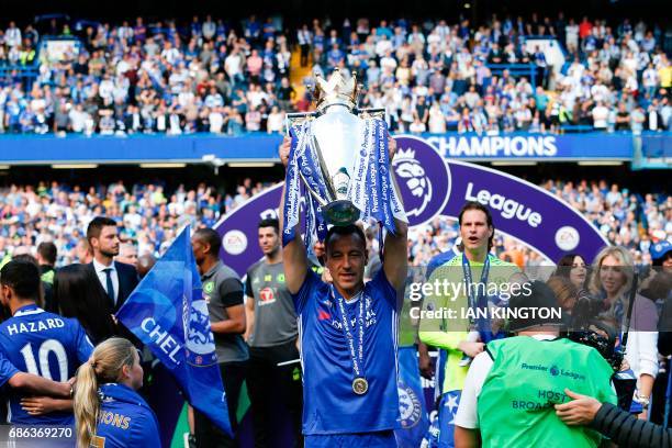 Chelsea's English defender John Terry raises the English Premier League trophy, as players celebrate their league title win at the end of the Premier...