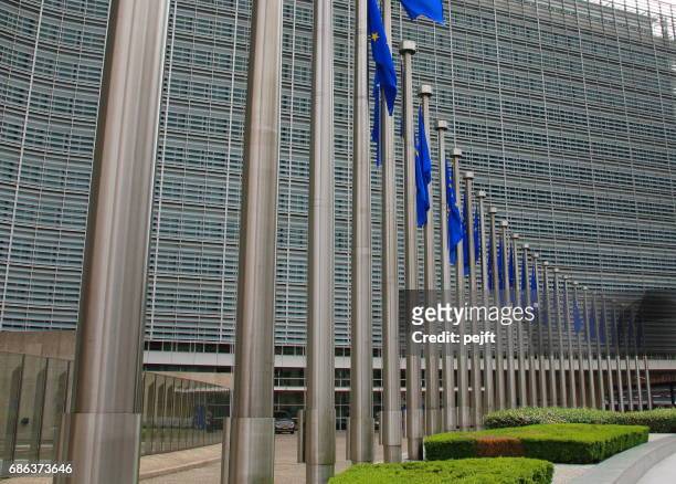 european commission building in brussels, belgium an eu flag - pejft stock pictures, royalty-free photos & images