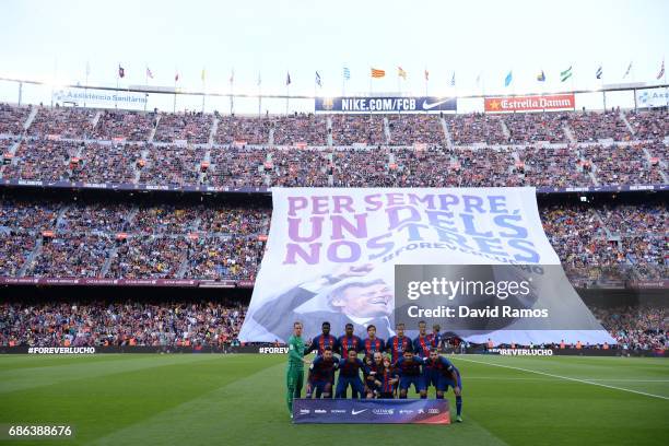 The teams line up as a banner is shown in tribute to Luis Enrique, Manager of Barcelona during the La Liga match between Barcelona and Eibar at Camp...