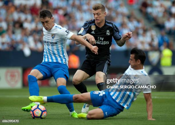 Malaga's Argentinian defender Federico Ricca Rostagnol and Malaga's defender Luis Hernandez vie with Real Madrid's German midfielder Toni Kroos...