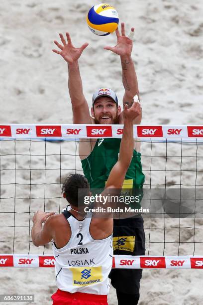 Alison Cerutti of Brazil blocks the ball during the Men's Finals match against Piotr Kantor and Bartosz Losiak of Poland at Olympic Park during day...