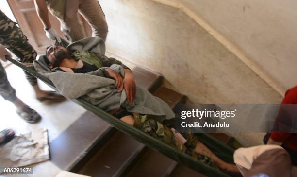 Man is being carried after a suicide attack against Ahrar al-Sham, an armed opposition group that fights against Assad Regime, at a headquarter in...