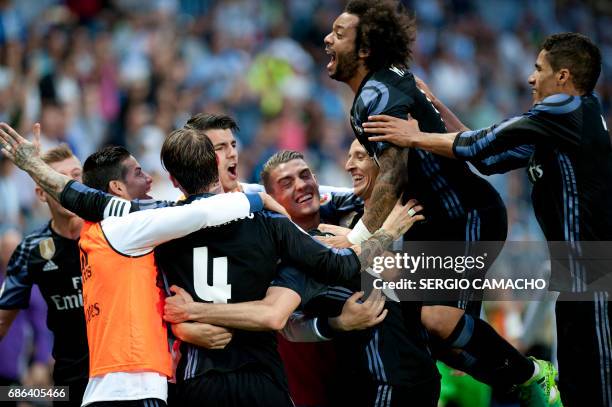 Real Madrid players celebrate a goal during the Spanish league football match Malaga CF vs Real Madrid CF at La Rosaleda stadium in Malaga on May 21,...