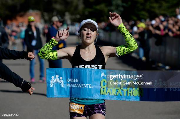 Brittany Lee raises her hands in the air as she crosses the finish line in first during the Colfax Marathon at City Park on May 21 in Denver,...