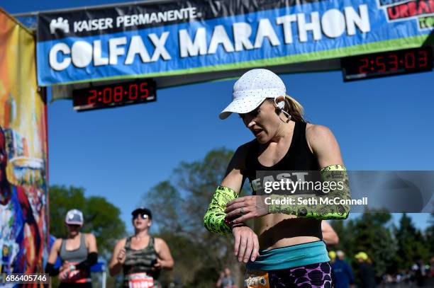Brittany Lee checks her watch after she crossed the finish line in first during the Colfax Marathon at City Park on May 21 in Denver, Colorado. The...