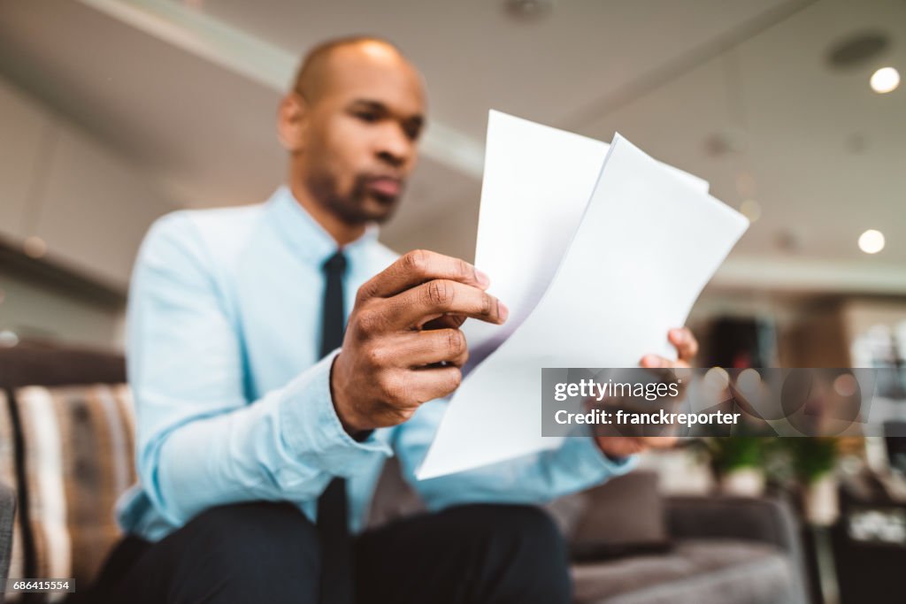 Businessman reading rading the bills at home