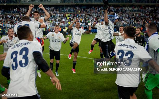 Real Madrid players celebrate at the end of the Spanish league football match Malaga CF vs Real Madrid at La Rosaleda stadium in Malaga on May 21,...