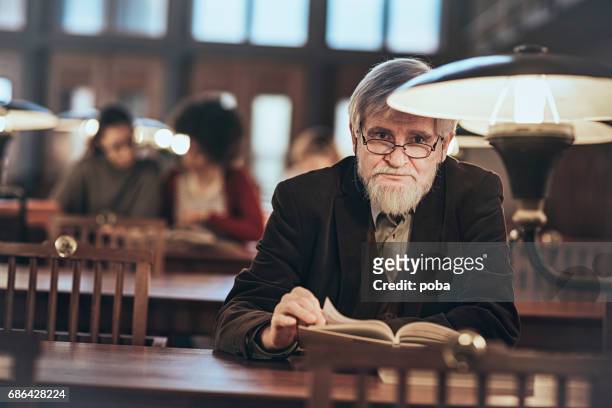 ritratto di uomo anziano in biblioteca - solo un uomo foto e immagini stock