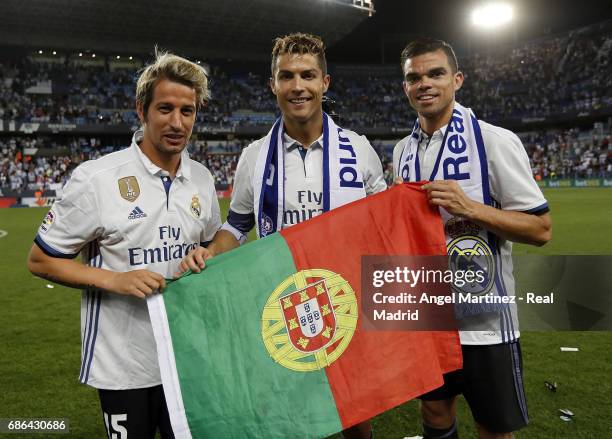 Fabio Coentrao, Cristiano Ronaldo and Pepe of Real Madrid celebrate winning the La Liga title following the La Liga match between Malaga CF and Real...