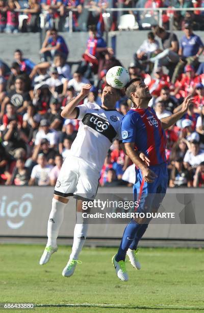 Olimpia's Julian Benitez vies for the ball with Santiago Molinas of Cerro Porteno during their Paraguayan Apertura 2017 tournament match at the...