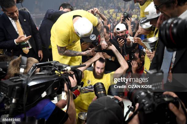 Fenerbahce's Luigi Datome gets his hair cut after winning the first place basketball match between Fenerbahce and Olympiacos at the Euroleague Final...