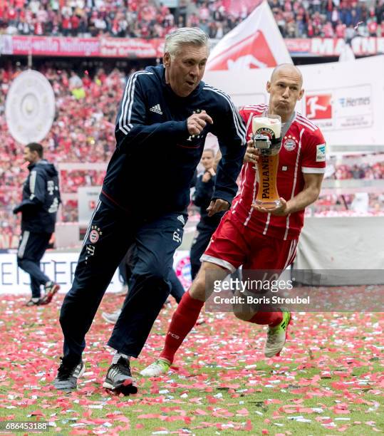 Arjen Robben of FC Bayern Muenchen tries to shower his head coach Carlo Ancelotti with beer in celebration of the 67th German Championship title...
