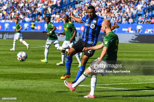 Portland Timbers defender Vytautas Andriuskevicius kiccking the ball and Montreal Impact forward Anthony Jackson-Hamel jumping in the air to avoid...