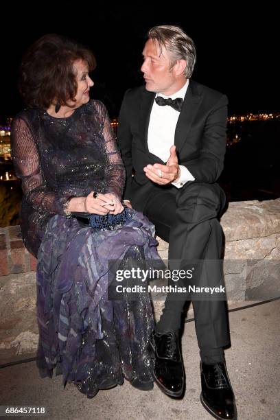 Claudia Cardinale and Mads Mikkelsen attend the Women in Motion Awards Dinner at the 70th Cannes Film Festival at Place de la Castre on May 21, 2017...