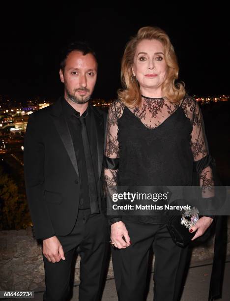 Anthony Vaccarello and Catherine Deneuve attend the Women in Motion Awards Dinner at the 70th Cannes Film Festival at Place de la Castre on May 21,...