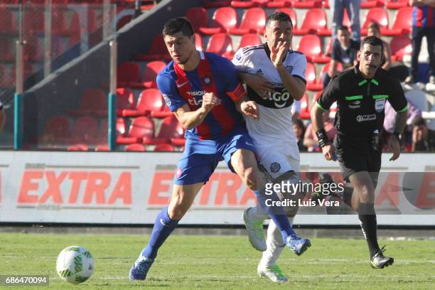 Rodrigo Rojas of Cerro Porteño fights for the ball with Julian Benitez of Olimpia during a match between Olimpia and Cerro Porteño as part of the...