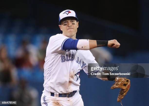 Chris Coghlan of the Toronto Blue Jays throws out the baserunner in the ninth inning during MLB game action against the Atlanta Braves at Rogers...