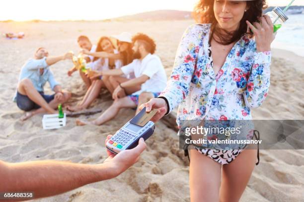 boho woman using credit card for contactless payment on beach - first job stock pictures, royalty-free photos & images