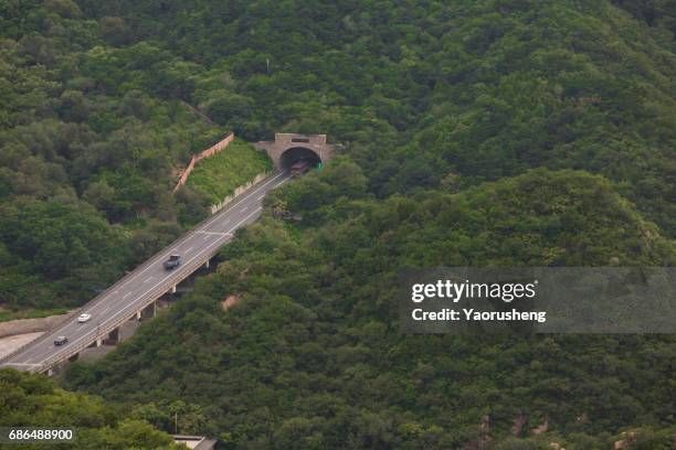 aerial view of highway leading to tunnel through a big mountain - zuid china stockfoto's en -beelden