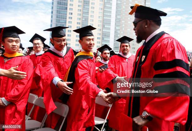 Graduates reached out to shake hands with former Boston Red Sox player David Ortiz during Boston University Commencement on Nickerson Field on campus...