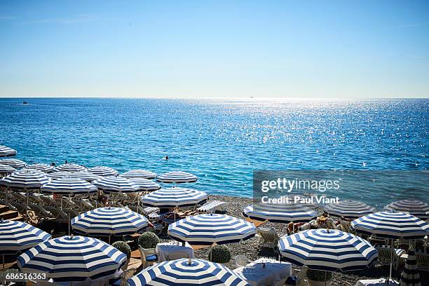 strippped beach umbrellas - costa azzurra foto e immagini stock