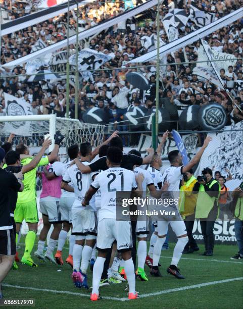 Edcarlos Conceicao of Olimpia celebrates with teammates Hernan Pellerano and Fernando Gimenez after winning a match between Olimpia and Cerro Porteño...