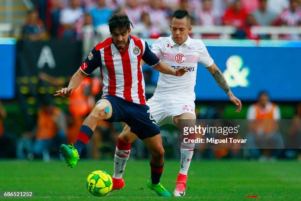 Rodolfo Pizarro of Chivas fights for the ball with Rodrigo Salinas of Toluca during the semi final second leg match between Chivas and Toluca as part...