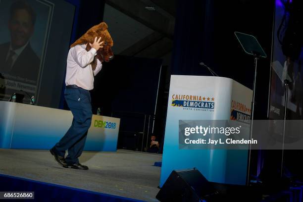 California State Senator Josh Newman walks onstage wearing a bear mask, before addressing delegates on the final day of the California Democratic...