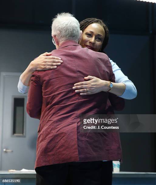 Playwright Robert Schenkkan hugs actress Tamara Tunie during curtain call on the opening night of "Building The Wall" at New World Stages on May 21,...