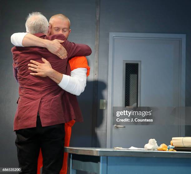 Playwright Robert Schenkkan hugs actor James Badge Dale during curtain call on the opening night of "Building The Wall" at New World Stages on May...