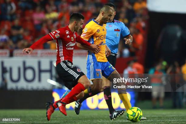 Luis Chavez of Tijuana struggles for the ball with Guido Pizarro of Tigres during the semi final second leg match between Tijuana and Tigres UANL as...