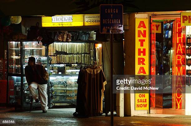 Vendor waits for customers in his shop located next door to a pharmacy advertising Anthrax medications December 10, 2001 in the border city of...