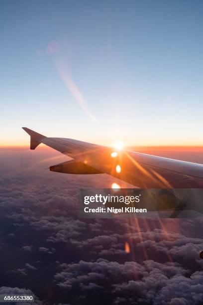 flying at sunset - ala de avión fotografías e imágenes de stock