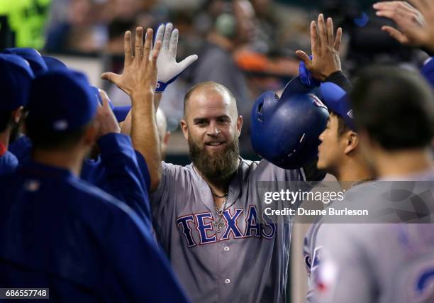 Mike Napoli of the Texas Rangers celebrates with teammates after hitting a solo home run against the Detroit Tigers during the fifth inning at...