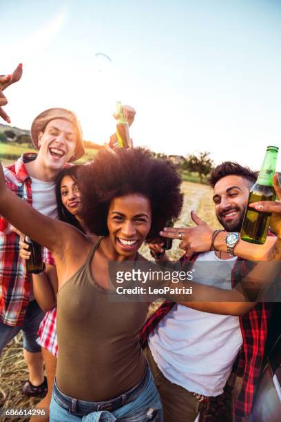 young friends enjoying the freedom on a car trip over a country offroad - country concert stock pictures, royalty-free photos & images