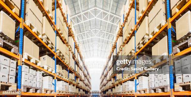 rows of shelves with boxes in modern warehouse - armazém de distribuição imagens e fotografias de stock