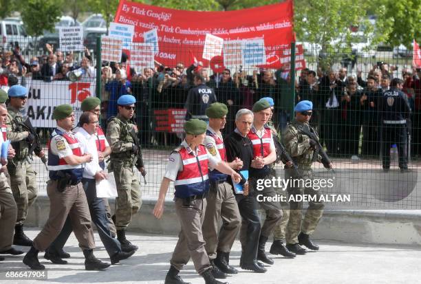 People hold banners as Turkish Gendarmerie escort defendants Akin Ozturk and others involved in last Julys attempted coup in Turkey as they leave the...