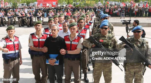 People hold banners as Turkish Gendarmerie escort defendants Akin Ozturk and others involved in last Julys attempted coup in Turkey as they leave the...