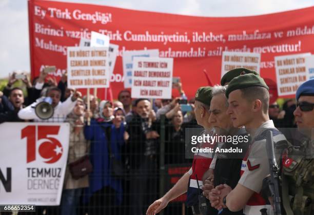 Protestors shout slogans as Turkish Gendarmerie escort defendants Akin Ozturk and others involved in last Julys attempted coup in Turkey as they...