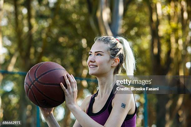 blonde teenager aiming basketball - brooke fasani stock pictures, royalty-free photos & images