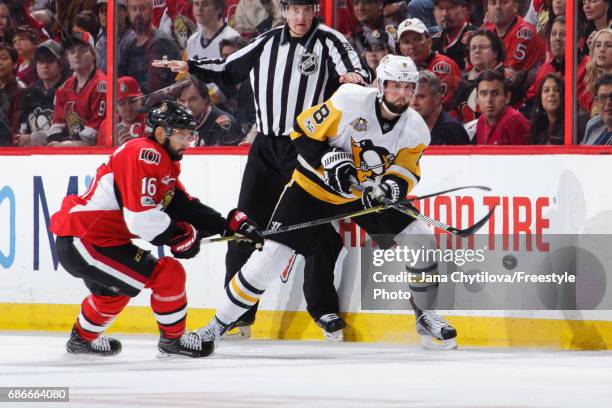 Brian Dumoulin of the Pittsburgh Penguins chips the puck past Clarke MacArthur of the Ottawa Senators in Game Four of the Eastern Conference Final...