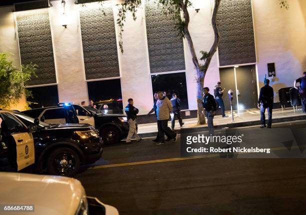 One of two suspects in a homicide is handcuffed in front of a social club May 18, 2017 in the Hollywood section of Los Angeles, California. Los...