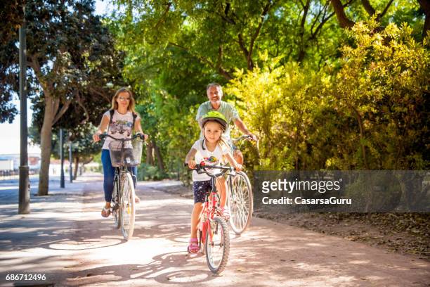 vater mit zwei töchtern mit fahrrad in valencia - two kids with cycle stock-fotos und bilder