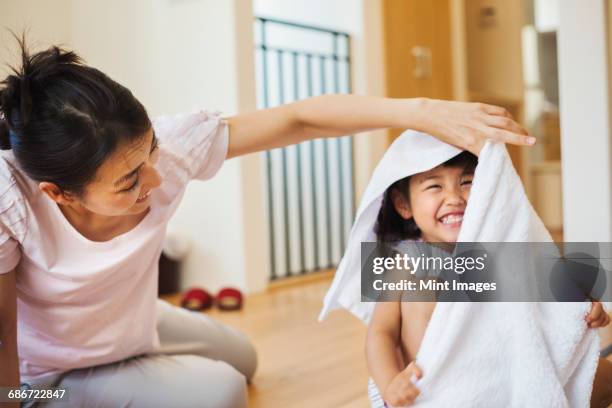 family home. a woman and her daughter folding clean laundry. - 洗い物 ストックフォトと画像