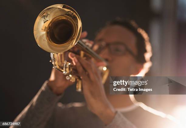 mid adult man playing trumpet - tromba foto e immagini stock