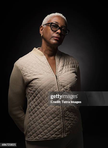 studio shot of woman standing with hands behind back - encuadre de tres cuartos fotografías e imágenes de stock