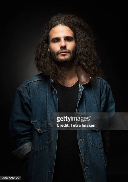 portrait of man in denim jacket on black background - man in denim jacket stock pictures, royalty-free photos & images