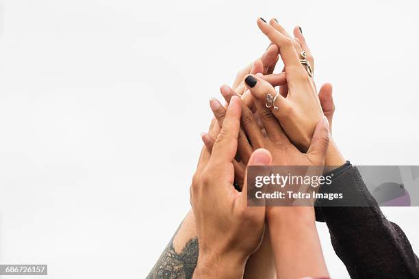friends holding their hands together - handen ineengevouwen stockfoto's en -beelden