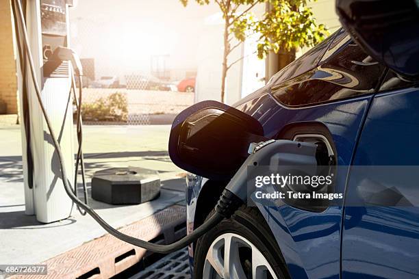 electric car recharging in charging station - stromtankstelle stock-fotos und bilder