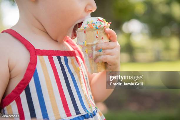 baby girl (18-23 months) eating ice-cream - girl eating messy ice cream cone stock pictures, royalty-free photos & images